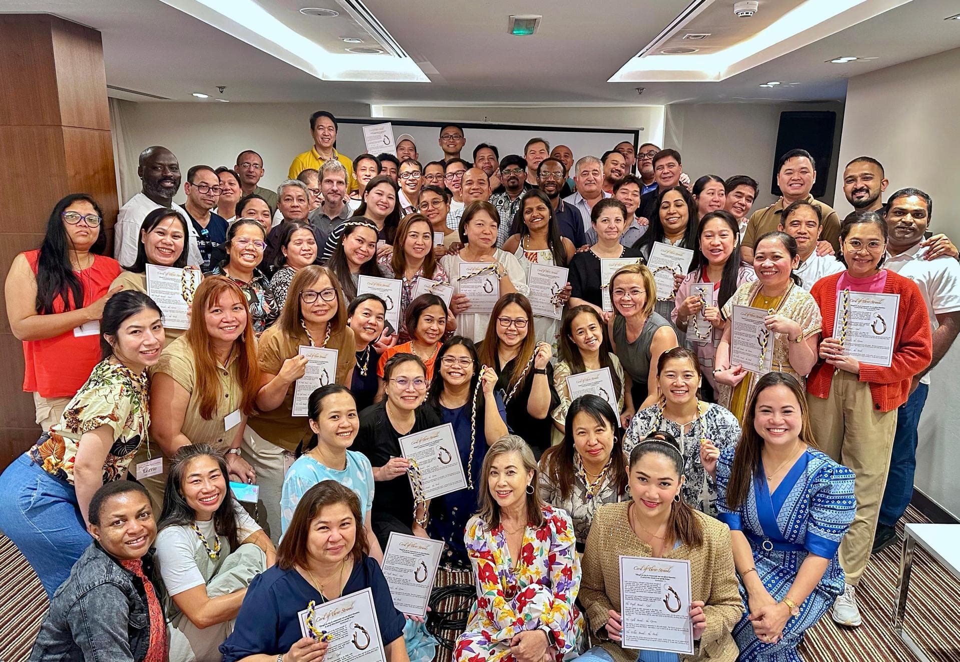 Married couples at an ICOC UAE retreat, holding Cord of Three Strands certificates